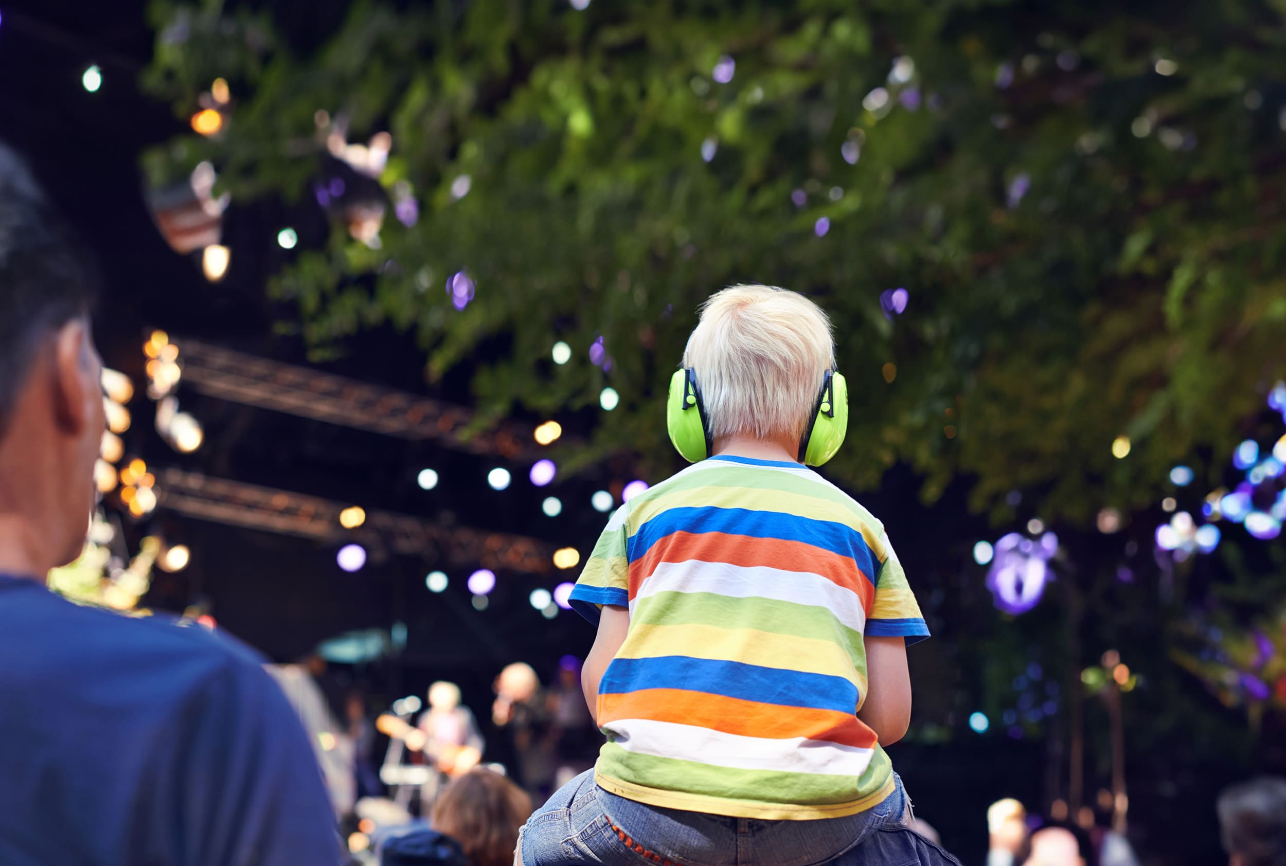 Kid wearing hearing protection while enjoying a live music festival
